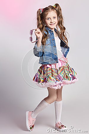 Fashion redhead girl in a festive outfit posing and smiling. Studio photo on light coloured background. Birthday, holiday Stock Photo