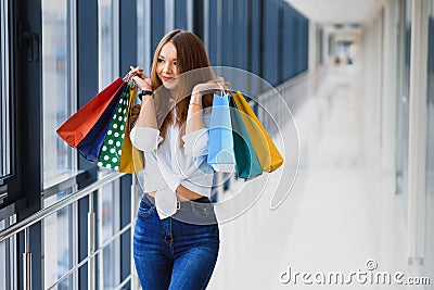 Fashion Shopping Girl Portrait. Beauty Woman with Shopping Bags in Shopping Mall. Shopper. Sales. Shopping Center Stock Photo