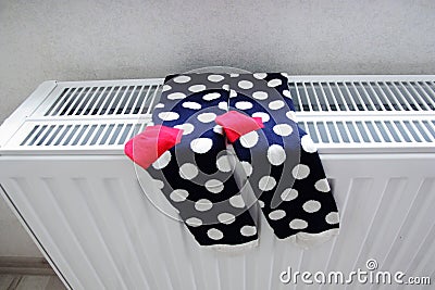 Fashion socks drying on heating radiator Stock Photo