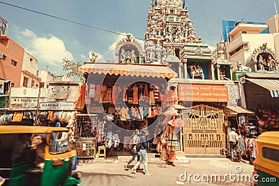 Fashion store and people walking past hindu temple on asian city street Editorial Stock Photo