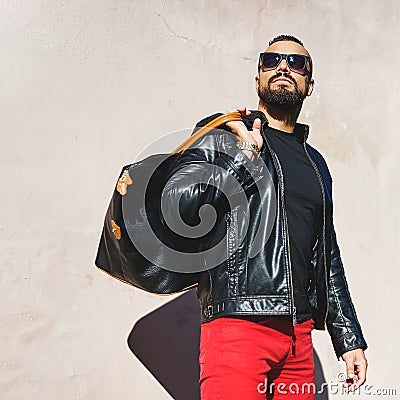 Fashion street portrait of handsome stylish man with handbag Stock Photo