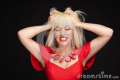 Fashion stressed blonde woman in red dress shout with open mouth holding head by hand medium closeup Stock Photo