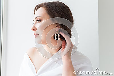 Close-up portrait of beautiful young woman with elegant hairstyle and luxurious jewelry and bijouterie. Stock Photo