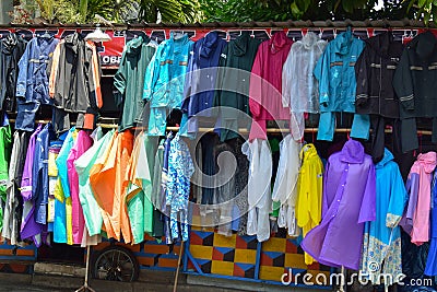 Fashion waterproof colorful raincoat hanging on hanger at clothes shop in the road side Editorial Stock Photo