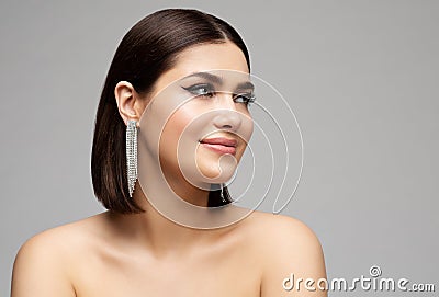 Fashion Woman Face Profile with Silver Diamond Earrings. Glamour Beauty Model with Bob Hairstyle Side view over Gray. Stylish Stock Photo