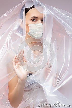 Fashion woman in polyethylene wearing protective mask. Stock Photo