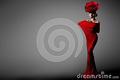 Fashion Woman in Red Dress Rose Flower Crown Hairstyle. Elegant Sexy Model in Floral Hat Bodycon Gown. Copy Space. Gray Studio Stock Photo