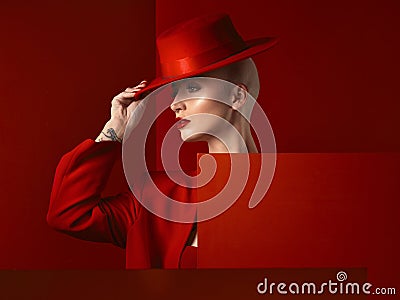 Fashion, woman and red hat with cosmetic or luxury in studio red background with creative retro suit. Style, runway and Stock Photo