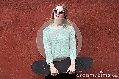 Fashion woman with a skateboard. Girl in sunglasses with longboard Stock Photo