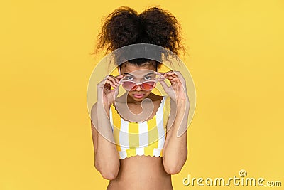 Fashion young african girl wear glasses look at camera isolated on yellow wall Stock Photo