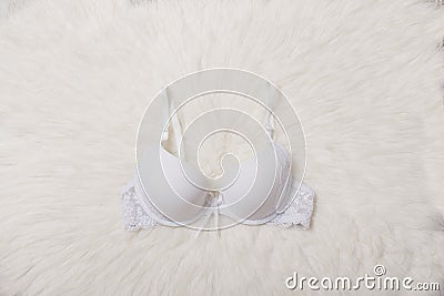 Fashionable concept. Female underwear. White bra with lace on white fur. Stock Photo