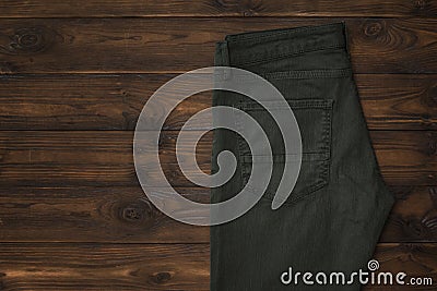 Fashionable dark green men`s jeans on a wooden background. Stock Photo