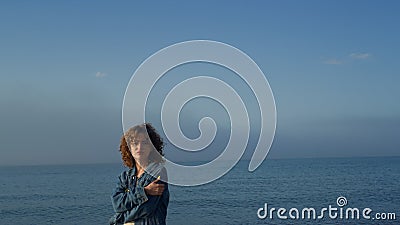 Fashionable girl looking at camera on seaside. Upset woman posing on beach Stock Photo