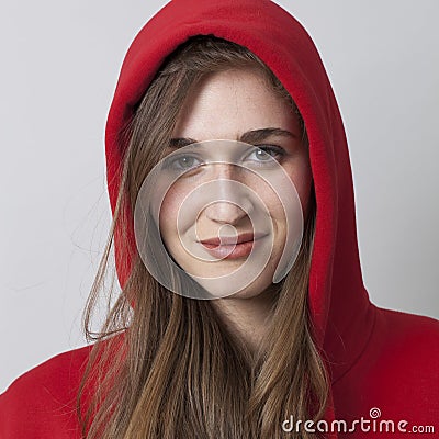 Fashionable happy 20s girl wearing a hoodie on for coolness Stock Photo