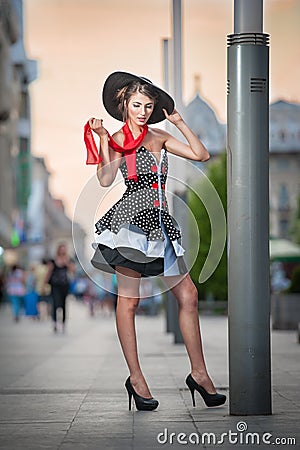 Fashionable lady wearing black hat posing on the street Stock Photo