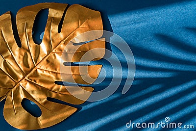 Fashionable luxuary blue background with gold monstera leaf. Copy space for text Stock Photo