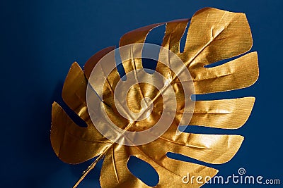Fashionable luxuary blue background with gold monstera leaf Stock Photo