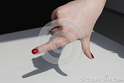 Fashionable makeup woman's finger nail polish, make the modelling of a pistol on the table Stock Photo