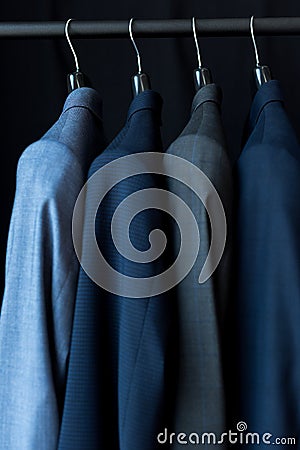 fashionable male suit jackets on hangers Stock Photo