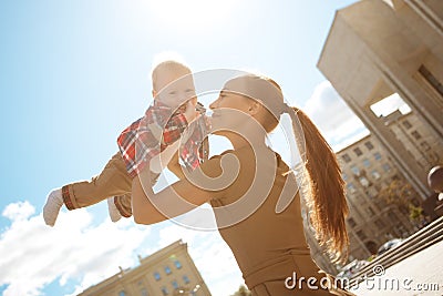 Fashionable modern mother on a urban street with a pram. Young m Stock Photo