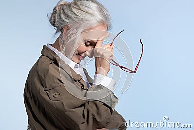 Fashionable senior woman in trench smiling Stock Photo