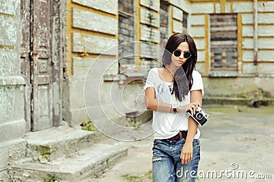 Fashionable stylish girl with old camera wearing sunglasses and Stock Photo