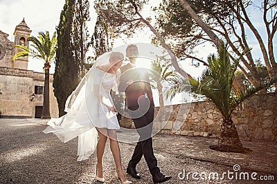 Fashionable wedding couple near Catholic church. Bride and Groom. Outdoor portrait Stock Photo