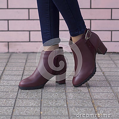 Fashionable woman wearing bordeaux colored elegant and beautiful leather heels decorated with belts Stock Photo