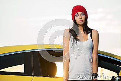Young fashion punk woman standing next to car Stock Photo