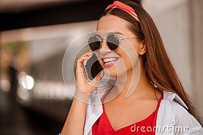A stylish woman talking on the phone and smiling Stock Photo