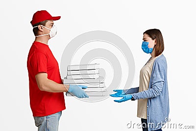 Fast delivery during quarantine. Courier giving boxes of pizza to girl client Stock Photo