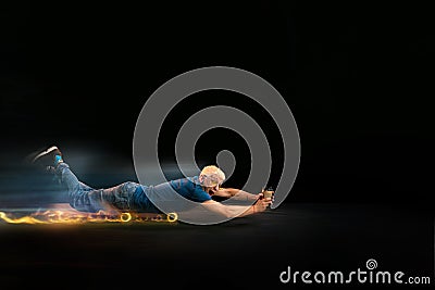 Fast delivery service - deliveryman on skateboard driving with order in fire on dark background Stock Photo