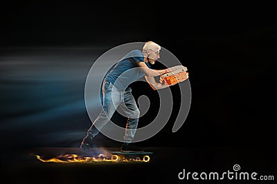 Fast delivery service - deliveryman on unicycle driving with order in fire on dark background Stock Photo