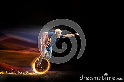 Fast delivery service - deliveryman on unicycle driving with order in fire on dark background Stock Photo