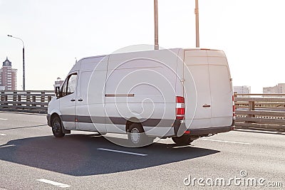 Fast delivery van drives on highway through city. commercial van is delivering cargo Stock Photo