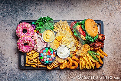 Fast food platter. Junk food concept. Unhealthy food for the heart, teeth, skin, figure, top view Stock Photo