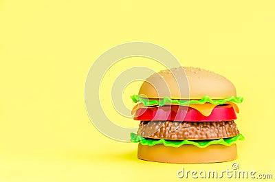 fast food. plastic hamburger on a yellow background Cartoon Illustration