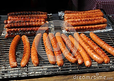 Cooking sausages on the grill for hot dogs. Foreground Stock Photo