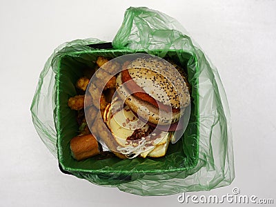 Fast food waste in a biodegradable garbage bag on a white Stock Photo