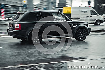 Fast moving black Range Rover Sport L320 on wet slippery road. Overspeed in city concept. SUV car on winter city road, side view Editorial Stock Photo