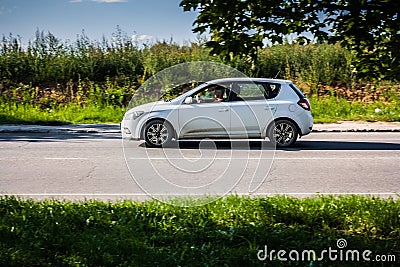 Fast moving Kia Ceed EW on the country road. Compact white hatchback with a man driving. First generation of popular Korean Editorial Stock Photo