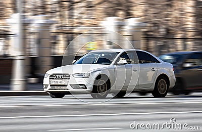 fast moving white car with motion blur effect. overspeed concept. Modern Audi A4 B8 auto goes fast on city road Editorial Stock Photo