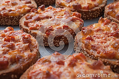 Fast Snack. Sesame Bread Baked With Salami And Cheese On Oven Tray. Mini Pizza. Stock Photo