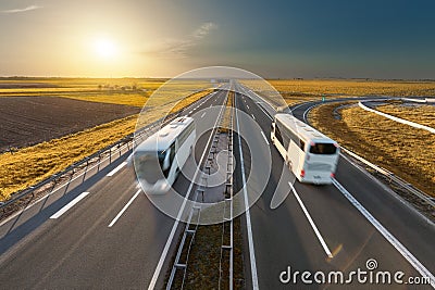 Fast travel buses on the highway at idyllic sunset Stock Photo