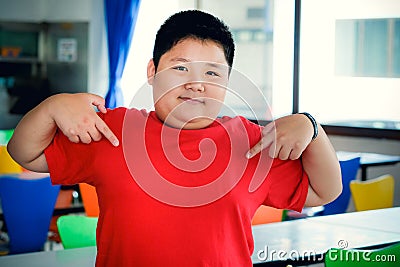 Fat Asian child boy has a smiling face, hands pointing at the chest Stock Photo