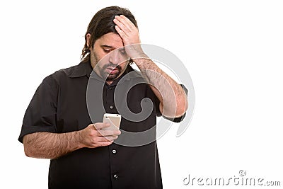 Fat Caucasian man looking tired while using mobile phone Stock Photo