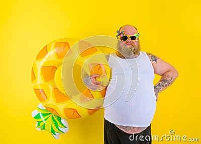 Fat delusion man with wig in head is ready to swim with a donut lifesaver Stock Photo