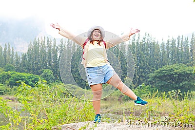 Fat female Asian tourist standing with arms and legs spread. Stock Photo