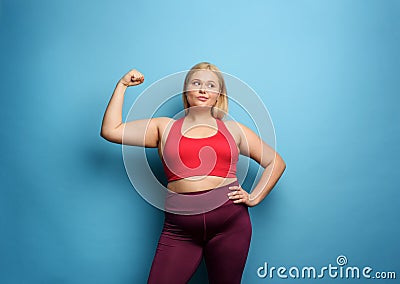 Fat girl does gym at home. thoughtful expression. Cyan background Stock Photo