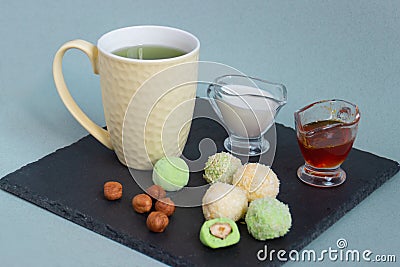 Fat keto peanut butter, cheesecake, matcha balls and keto matcha coconut bulletproof tea in yellow cup. keto protein balls and Stock Photo